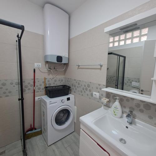 a bathroom with a washing machine and a sink at Noli's Apartment in Shëngjin