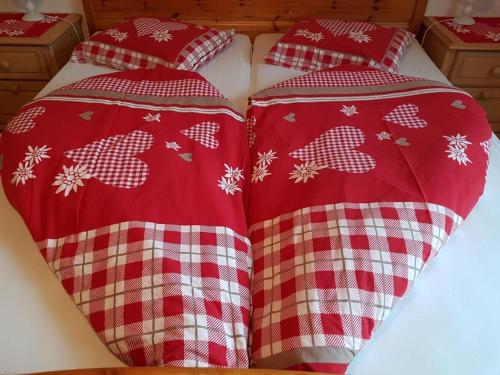 two beds with red and white pajamas at Ferien Im Gugger Wohnung Stockberg in Nesslau