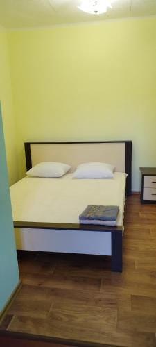a bed with two pillows and a book on it at Хуторок у Зіни in Sanzhiyka