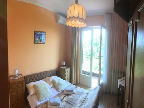 a small bedroom with a bed and a window at Guesthouse Villa Manda in Lovran