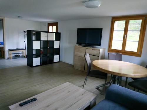 a living room with a table and a tv at Thal in Vitznau