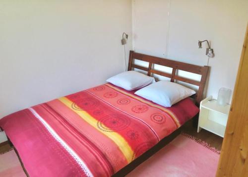 a bedroom with a bed with a red and yellow blanket at Pilgerwohnung in Wald