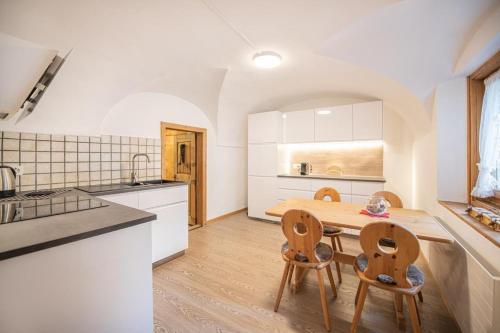 a kitchen with a table and chairs in a room at Chesa Treig in Samedan