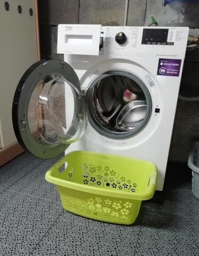 a washing machine with a green basket next to it at Bella Vista in Sörenberg