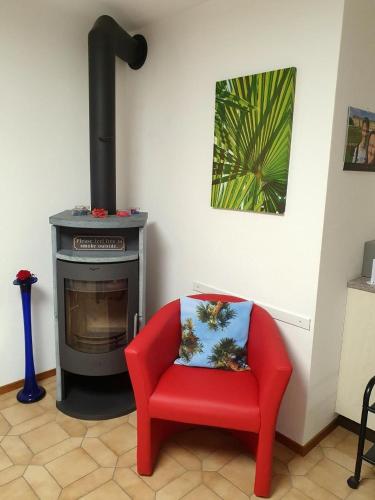 a red chair sitting in front of a stove at Casa Ghiggi Ticino in Brissago