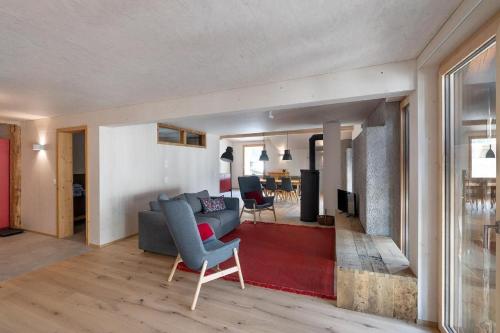 a living room with a couch and a red rug at Bellezza Bio Bergün in Bergün