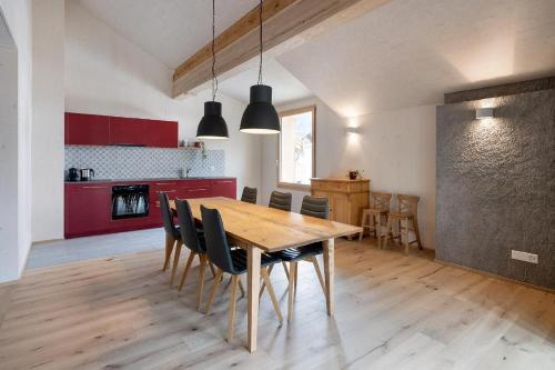 a kitchen and dining room with a wooden table and chairs at Bellezza Bio Bergün in Bergün