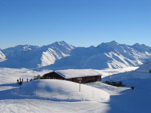 a building on top of a snow covered mountain at Gemütliche Ferienwohnung Im Disentiserhof in Disentis