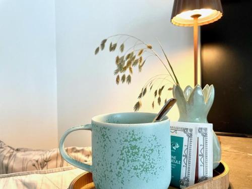 a blue coffee cup sitting on a table with a plant at Ferienwohnung Im Dorf Urnäsch in Urnäsch