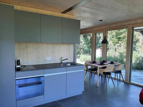 a kitchen with a sink and a table with chairs at Gartenbungalow 2 3 Personen in Arbon