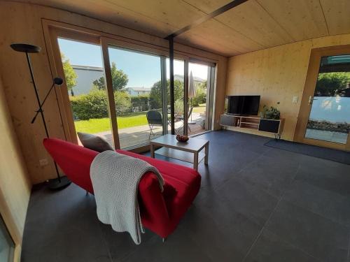 a living room with a red couch and a television at Gartenbungalow 2 3 Personen in Arbon