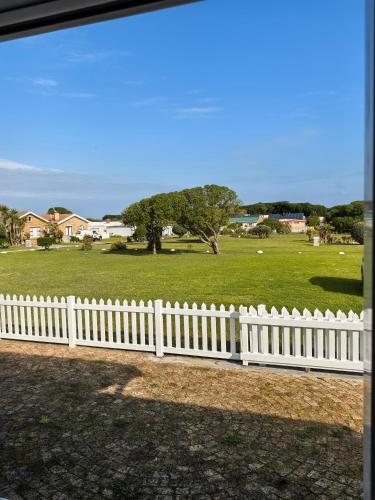 a white picket fence in front of a field at The Pearl in Pearly Beach