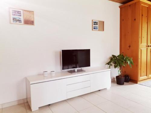 a living room with a tv on a white cabinet at Gemütliche Fewo in Innertkirchen