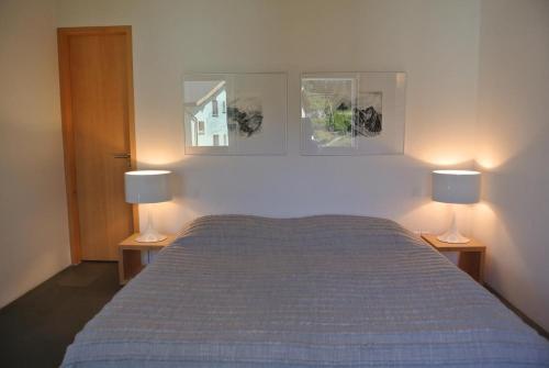 a bedroom with a bed with two lamps on it at La Montanella 4 in Maloja