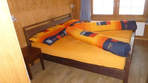 a bedroom with two beds with colorful sheets and pillows at Bauernhof Ufem Berg in Herisau