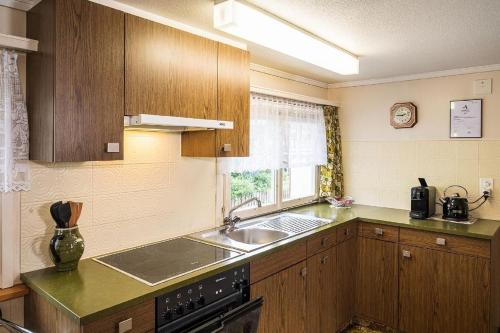 a kitchen with wooden cabinets and a sink and a window at Ferienhaus Wühre in Appenzell