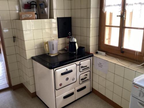 a kitchen with a white stove with a blender on it at Mannried 2 1 2 Zimmerwohnung Rustikal in Zweisimmen