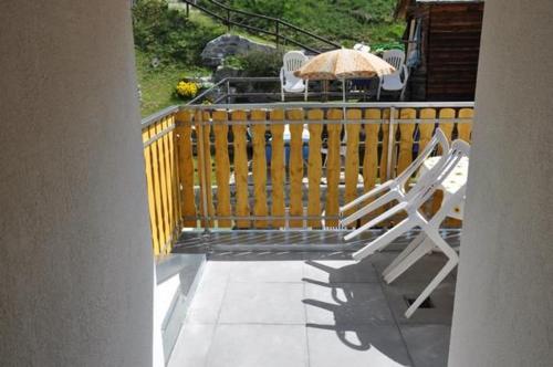 a deck with chairs and an umbrella on a porch at Haus Mattaboni in Zernez