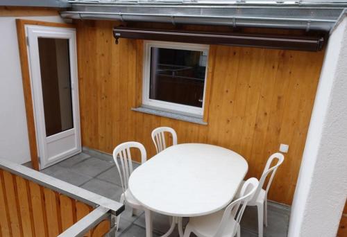 a white table and chairs on the balcony of a house at Haus Mattaboni in Zernez