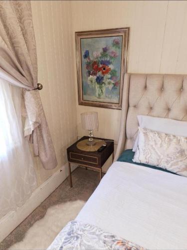 a bedroom with a bed and a table with a lamp at Richmond Hill Guest House in Port Elizabeth