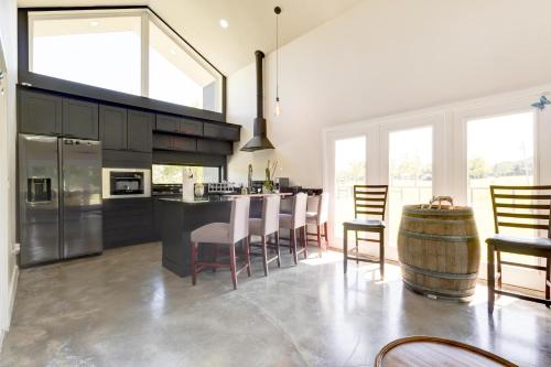 a kitchen with a bar with chairs and a barrel at Black Sheep Hideaway Modern Countryside Serenity in Clermont