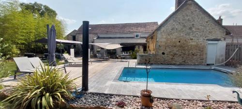 a swimming pool in the backyard of a house at GITE HARY in Villeblevin