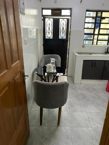 a room with a table and a chair and a table and a kitchen at Wonderstay D in Nairobi