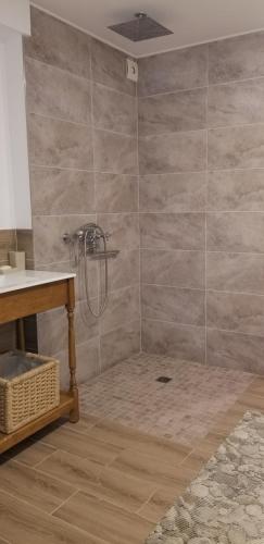 a bathroom with a shower with a stone wall at A&S Vidugiris in Jurbarkas