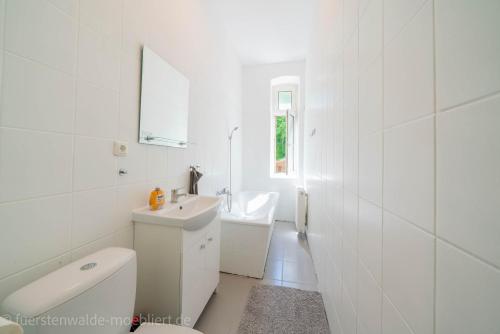 a white bathroom with a sink and a toilet at Apt Watt 2 Zimmer 55qm TV Waschmaschine Trockner Vollausstattung zentral in Fürstenwalde