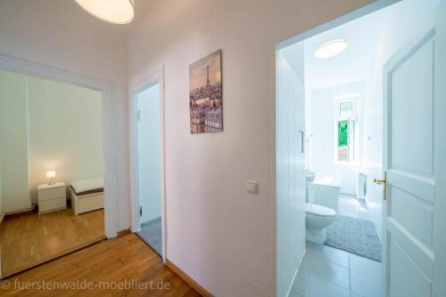 a white bathroom with a toilet and a sink at Apt Watt 2 Zimmer 55qm TV Waschmaschine Trockner Vollausstattung zentral in Fürstenwalde