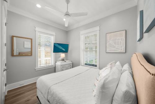 a white bedroom with a bed and two windows at Paradiso Del Mare by Stay on 30A, Gulf View- Private Pool! in Inlet Beach