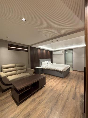 a large bedroom with a bed and a couch at Plaza 14 in Jammu