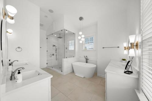 a white bathroom with a tub shower and a sink at Paradiso Del Mare by Stay on 30A, Gulf View- Private Pool! in Inlet Beach