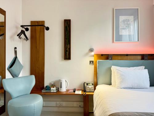 a bedroom with a bed and a chair and a desk at Conference Aston Hotel - Birmingham City in Birmingham