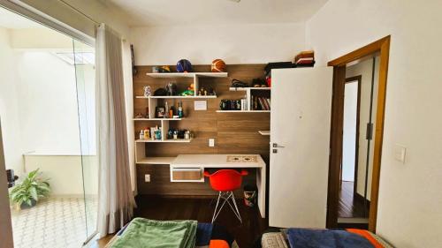 a small room with a desk and a refrigerator at Quarto expetacular in Timóteo