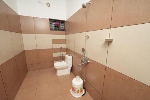 a bathroom with a toilet and a shower stall at VILLA MANTRAA in Varkala