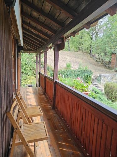 a porch with two wooden chairs sitting on it at Къща за гости Хитър Петър in Apriltsi