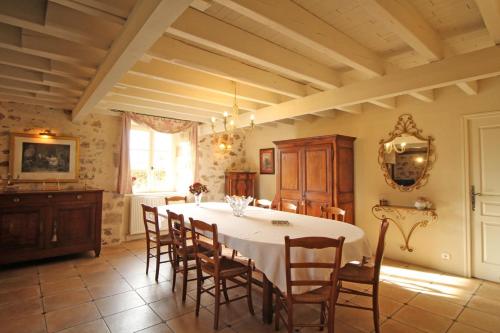 a dining room with a white table and chairs at Fonbanoux in Flavignac
