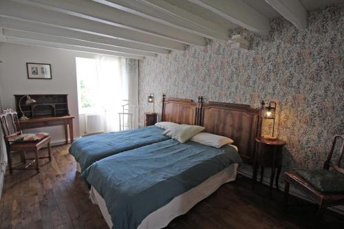 a bedroom with a bed with a blue comforter at Fonbanoux in Flavignac