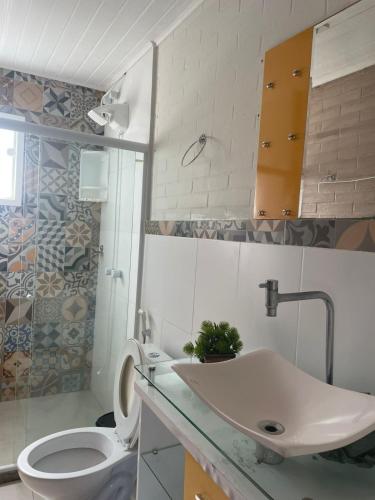 a bathroom with a white toilet and a sink at Casa con vista al mar in Búzios