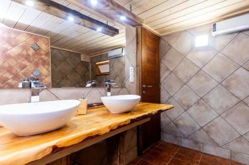 a bathroom with two white sinks on a wooden counter at Zalaidill Wellness Vendégház in Nagybakónak