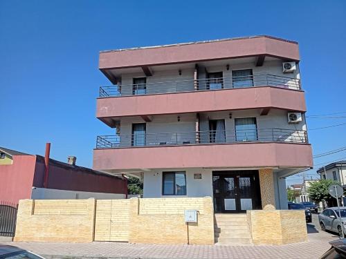 a tall building with a balcony on a street at StudioApartment LUXOR in Constanţa
