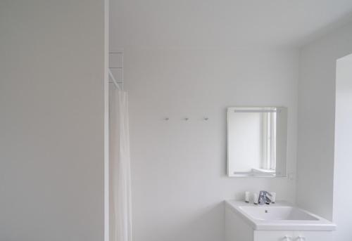a white bathroom with a sink and a mirror at 4-BR apartment with a balcony in Hellerup - 182 in Hellerup