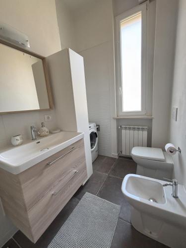a white bathroom with a sink and a toilet at Salso Experience apartment in Salsomaggiore Terme