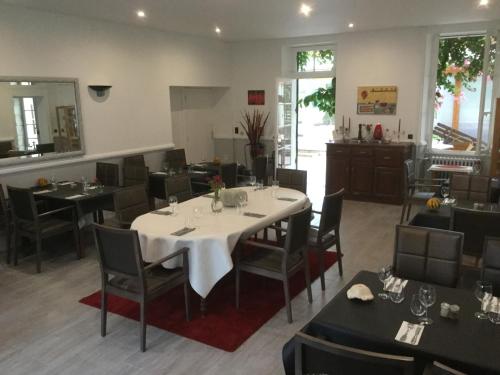 une salle à manger avec une table et des chaises blanches dans l'établissement L'Art Dit Vin, à Saint-Aigulin