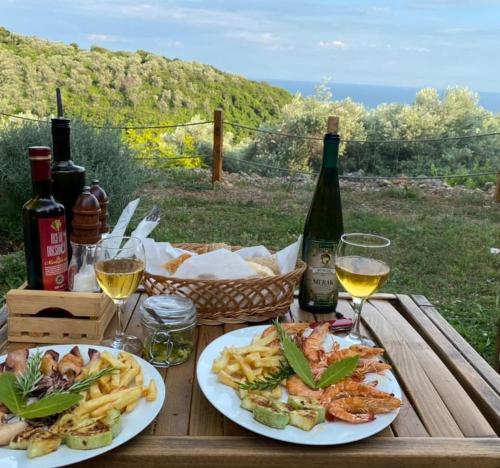 einen Holztisch mit zwei Teller Essen und Wein in der Unterkunft Villa Baccarat in Ulcinj
