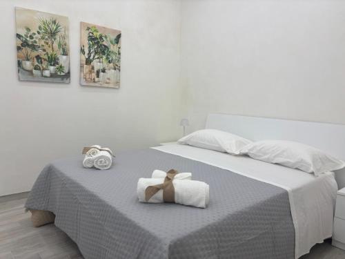 a bed with two towels and a bow on it at Corte Antica Marsala in Marsala