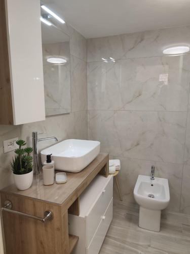 a bathroom with a sink and a toilet at Corte Antica Marsala in Marsala