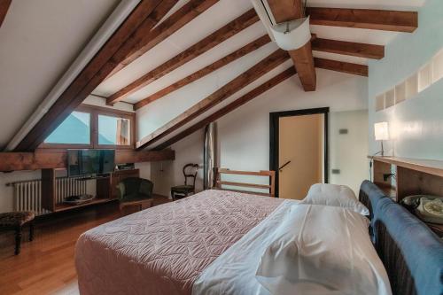a bedroom with a bed and a blue couch at Grace Suite with Jacuzzi Wonderful Lakefront View in Colonno