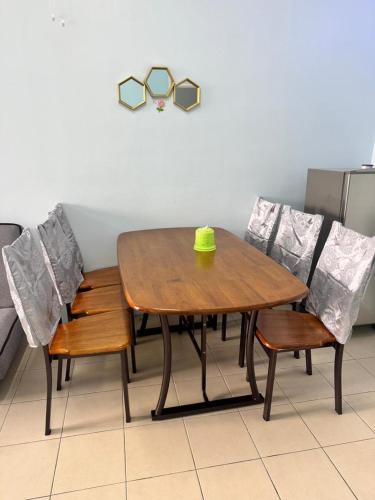 a wooden table and chairs with a green cup on it at AYAAN Fifa Game HOMESTAY At Tanah Rata with Wifi in Tanah Rata